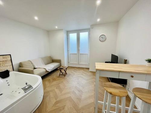 ein Wohnzimmer mit einer Badewanne und einem Sofa in der Unterkunft Bel appartement avec Jacuzzi #1 in Bourgoin