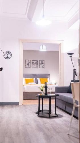 a living room with a couch and a table in front of a bed at Syntagma square, 65sqm cozy family apartment in Athens