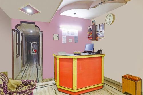 a room with a desk and a clock on a wall at Super Collection O Hotel Shree Narayan Regency in Kānpur