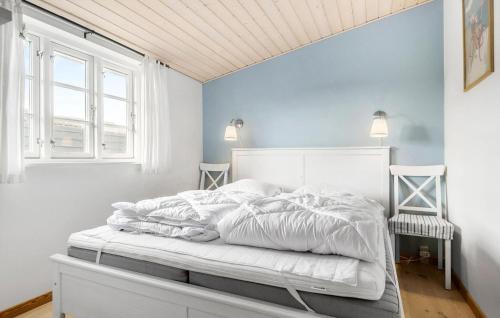 a white bed in a room with blue walls at 2 Bedroom Stunning Home In Karrebksminde in Karrebæksminde