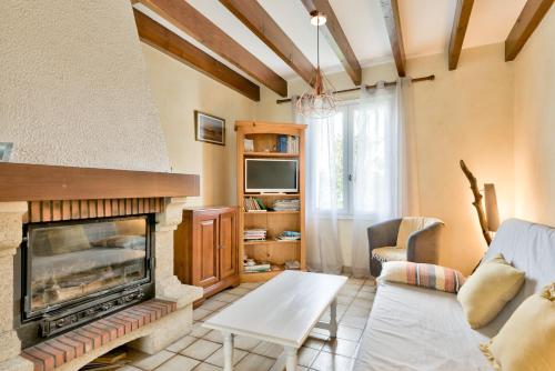 ein Wohnzimmer mit Kamin und Couch in der Unterkunft Lanton - 700m plage - Extérieur et charme in Cassy