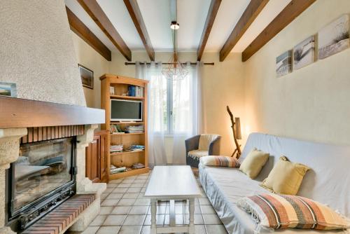un salon avec un canapé et une cheminée dans l'établissement Lanton - 700m plage - Extérieur et charme, à Lanton