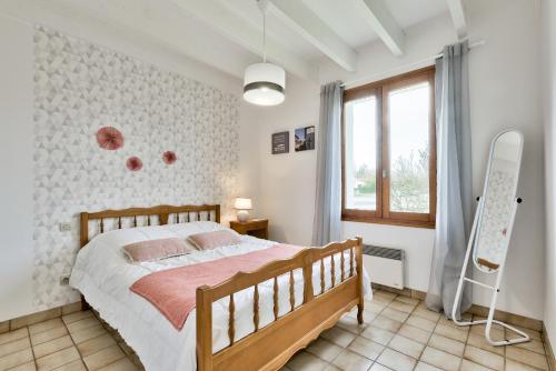 une chambre avec un grand lit et une fenêtre dans l'établissement Lanton - 700m plage - Extérieur et charme, à Lanton