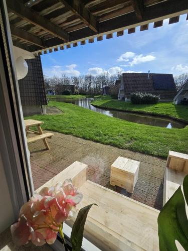 a view from a window of a patio at 6 pers. vakantiehuis aan visvijver op vakantiepark, Time4vacay in Gramsbergen