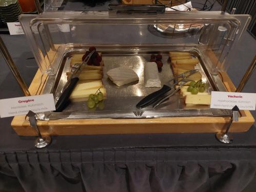 a display case with cheese and other food items at Hôtel Rallye & Entrées aux Bains de la Gruyère in Bulle