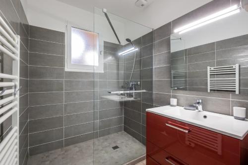 a bathroom with a sink and a glass shower at Accueillante maison avec jardin à Lanton in Lanton