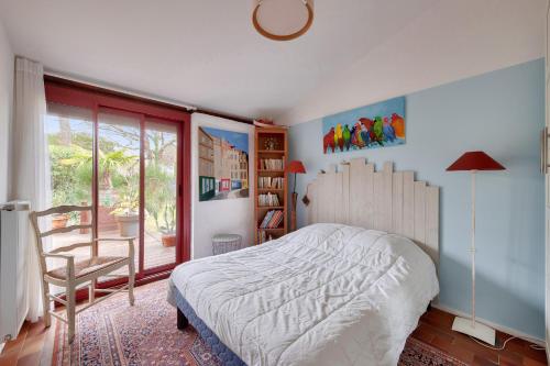 une chambre avec un lit, une chaise et une fenêtre dans l'établissement Maison pour 8 avec jardin et terrasse- Calme, à Andernos-les-Bains