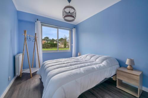 - une chambre bleue avec un grand lit et une fenêtre dans l'établissement Appartement pour 4 - centre - 500m de la plage, à La Baule