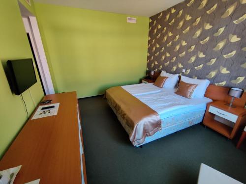 ペーチにあるBoutique Hotel Sopianaeのベッドとテレビが備わるホテルルームです。