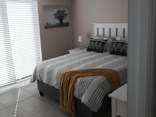 a bedroom with a bed with a blanket on it at K Partners' Boutique Hotel & Spa in Langebaan