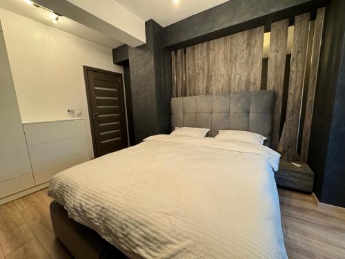 una camera con un grande letto con testiera in legno di Casa de la Luna Apartment a Iaşi