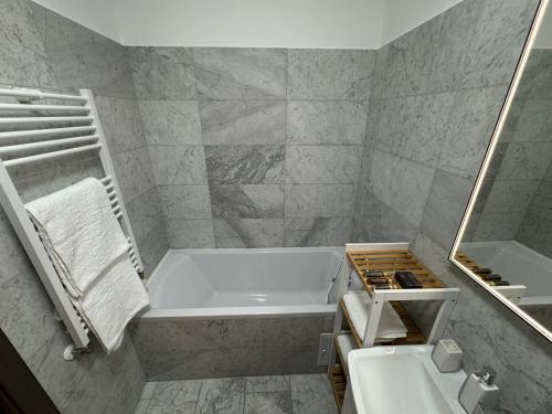 un bagno bianco con vasca e lavandino di Casa de la Luna Apartment a Iaşi