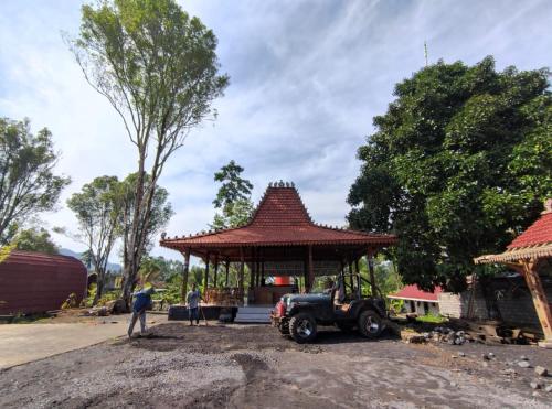 Sidomukti的住宿－Indah Damai Cottages，前面停着吉普车的凉亭