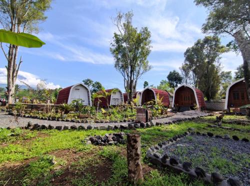 a group of huts in a garden at Indah Damai Cottages in Sidomukti