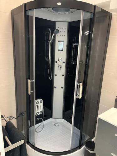 een badkamer met een douche en een glazen deur bij Appartement balenciaga in Échirolles