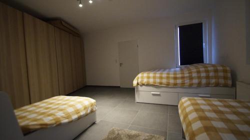 a small bedroom with two beds and a window at Ferienwohnung Best Apartments Leverkusen 2 in Leverkusen