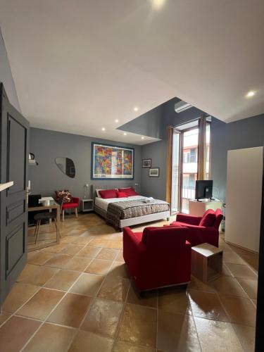 Cet appartement comprend une chambre avec un lit et un salon doté d'un mobilier rouge. dans l'établissement Naples Luxury Suites B&B, à Naples