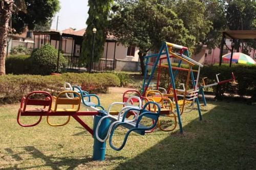 a group of colorful playground equipment in a park at Agabet Hotel - Mbale in Mbale