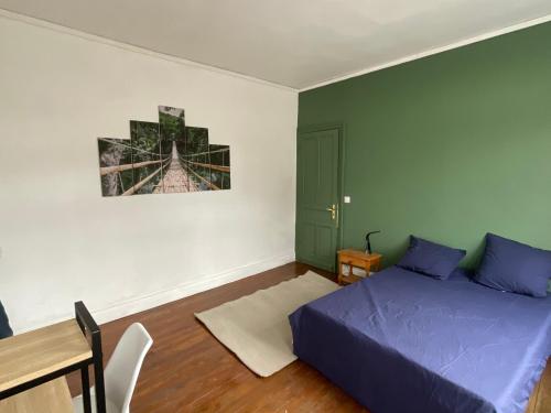 Schlafzimmer mit einem Bett, einem Tisch und einem Schreibtisch in der Unterkunft Ancienne maison de maitre in Douai