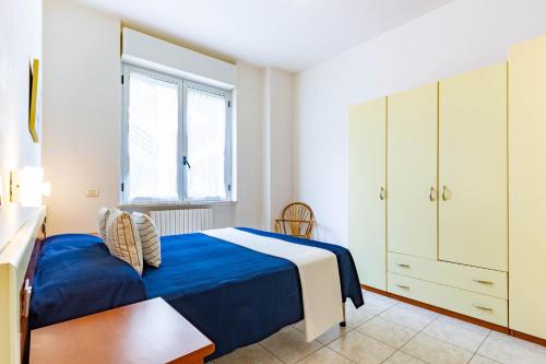 Un dormitorio con una cama azul y una ventana en Appartamento Pinolo Bilo INT 4 - MyHo Casa en Alba Adriatica