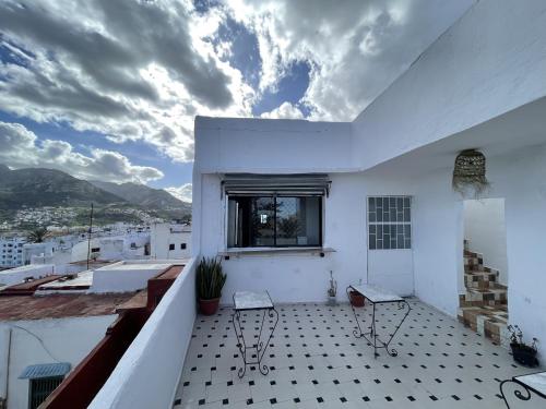 a balcony with two chairs and a window at Casa Marwan in Tetouan