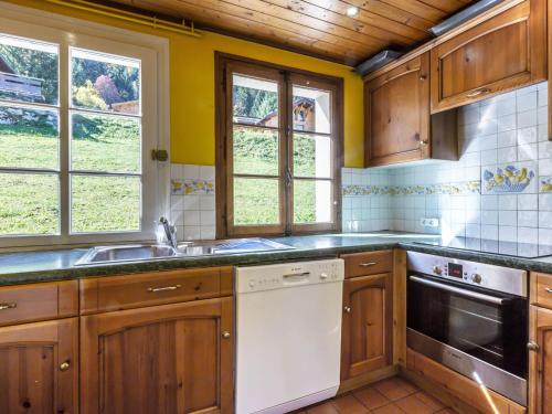 - une cuisine avec des placards en bois et un lave-vaisselle blanc dans l'établissement Chalet proche pistes, cheminée, garage, Wifi - FR-1-304-108, à La Clusaz