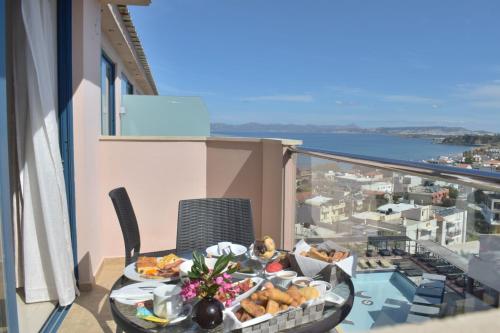 a table with a tray of food on a balcony at Galini Sea View Hotel in Agia Marina Nea Kydonias