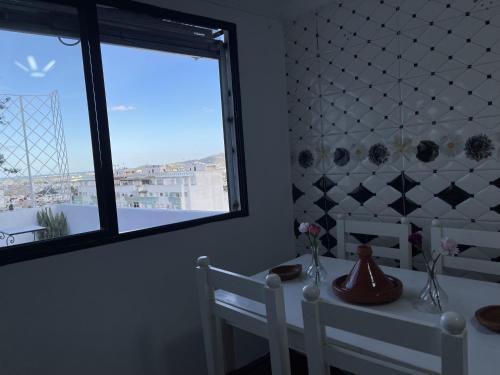 a dining room with a table and chairs and a window at Casa Marwan in Tetouan