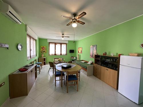 a kitchen with green walls and a table and chairs at Appartamento a 50 metri dal mare a Maladroxia C36 in Maladroxia