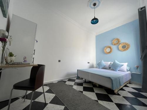 a bedroom with a bed and a black and white checkered floor at Casa Marwan in Tétouan