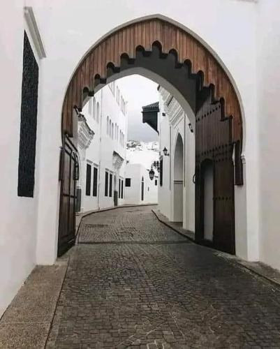 an alley with an archway in a white building at Casa Marwan in Tetouan