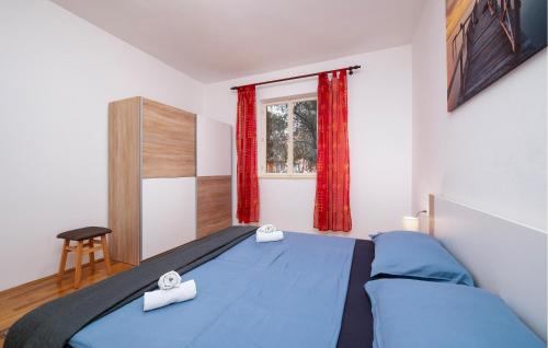 Un dormitorio con una cama azul y una ventana en 2 Bedroom Beautiful Apartment In Fazana, en Fažana