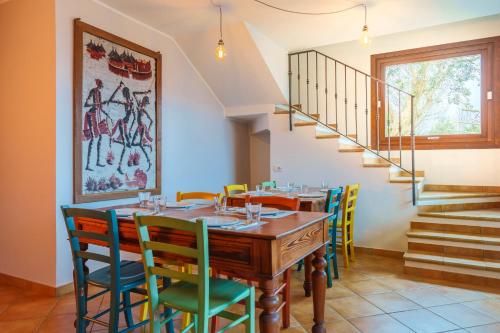 a dining room with a wooden table and colorful chairs at Bergamo bnb in Villa di Serio