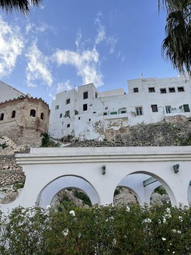 a white building with an arch over a bridge at Casa Marwan in Tetouan