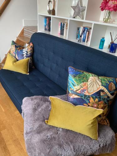 un sofá azul con almohadas en la sala de estar en Central Windsor and Castle, Legoland 2.6 miles Away, en Windsor