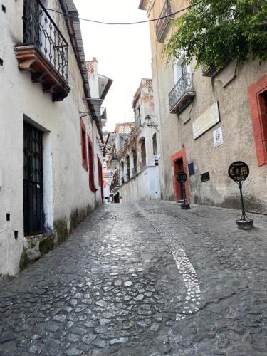 eine leere Straße in einer Gasse zwischen zwei Gebäuden in der Unterkunft Chalet la Adornada in Taxco de Alarcón