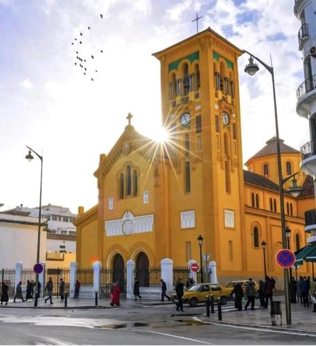 a large yellow building with a clock tower at Casa Marwan in Tetouan