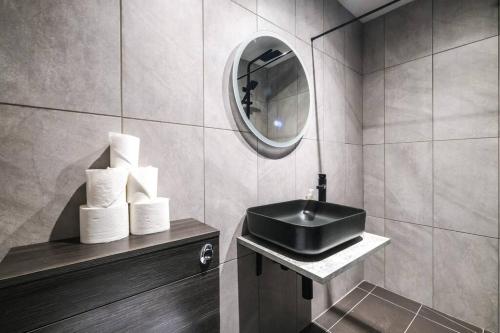 La salle de bains est pourvue d'un lavabo et d'un miroir. dans l'établissement Quaint and Spacious Piccadilly Sleep 6 VRD, à Londres
