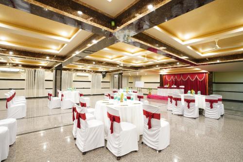 バンガロールにあるVista Suites, Bangaloreの白いテーブルと赤い弓の宴会場