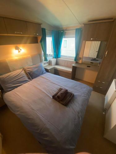 阿士頓的住宿－Impeccable 2-Bed Lodge in Ashington，一间卧室配有一张床,床上有毛巾