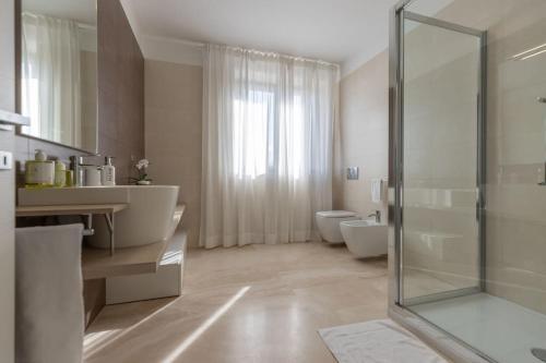 een badkamer met 2 toiletten en een glazen douche bij [Villa Luxury] Piscina BBQ Free Parking in Capodarco