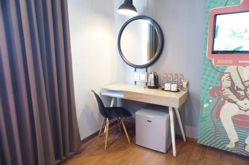 a dressing room with a desk and a mirror at Hotel Fortunagrande Jember By Fosia Hotels in Jember