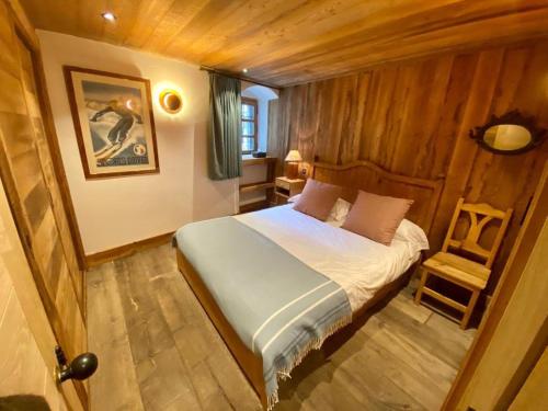 une chambre avec un lit et une chaise dedans dans l'établissement L'Illaz - 4 bedrooms, log fire, à Val dʼIsère