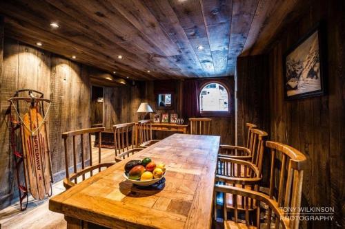 - une table en bois avec un bol de fruits dans l'établissement L'Illaz - 4 bedrooms, log fire, à Val dʼIsère