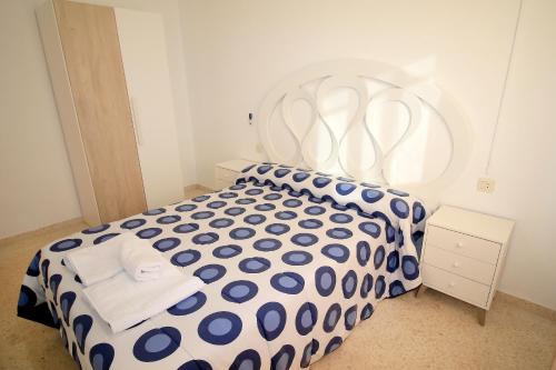 um quarto com uma cama com um edredão azul e branco em Apartamento Luna Llena Golf de San Juan de los Terreros em San Juan de los Terreros