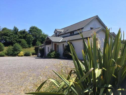 a white house with a gravel driveway at Kenmare Eco Lodge in Kenmare