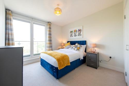 um quarto com uma cama azul e uma janela em Modern 2 Bed Apartment in Crawley - Sleeps 5 em Crawley