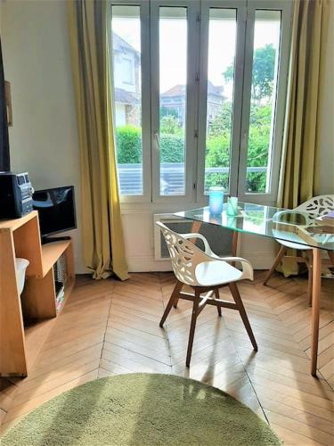 - un salon avec une table en verre et une chaise dans l'établissement Appartement avec terrasse entre Versailles et Paris, à Marnes-la-Coquette
