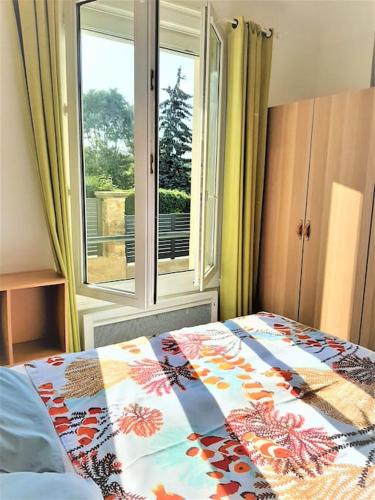 une chambre avec un lit et une fenêtre dans l'établissement Appartement avec terrasse entre Versailles et Paris, à Marnes-la-Coquette