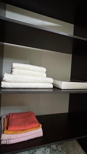 a shelf with folded towels and towels on it at Апартаменты посуточно in Atyrau